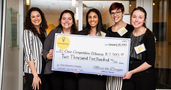 Winning students pose with giant check